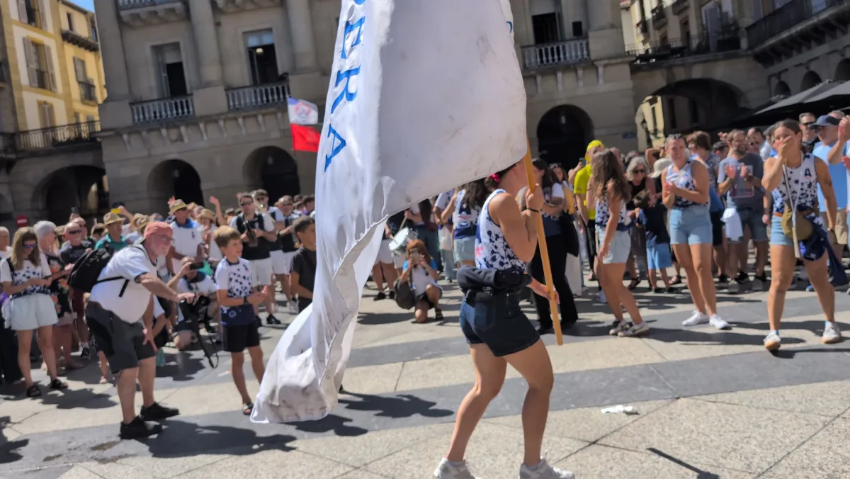 La bandera, de paseo por la plaza de la Constitución entre aplausos, después de la regata.